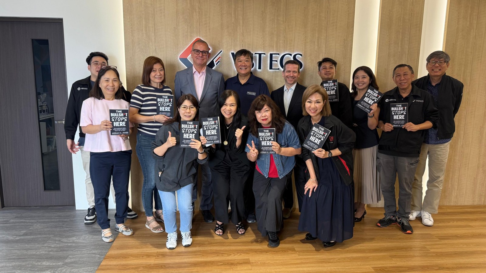The ECS management team at VSTECS Singapore holding signed copies of The Bullsh*t Stops Here with Adrian M. Jones.